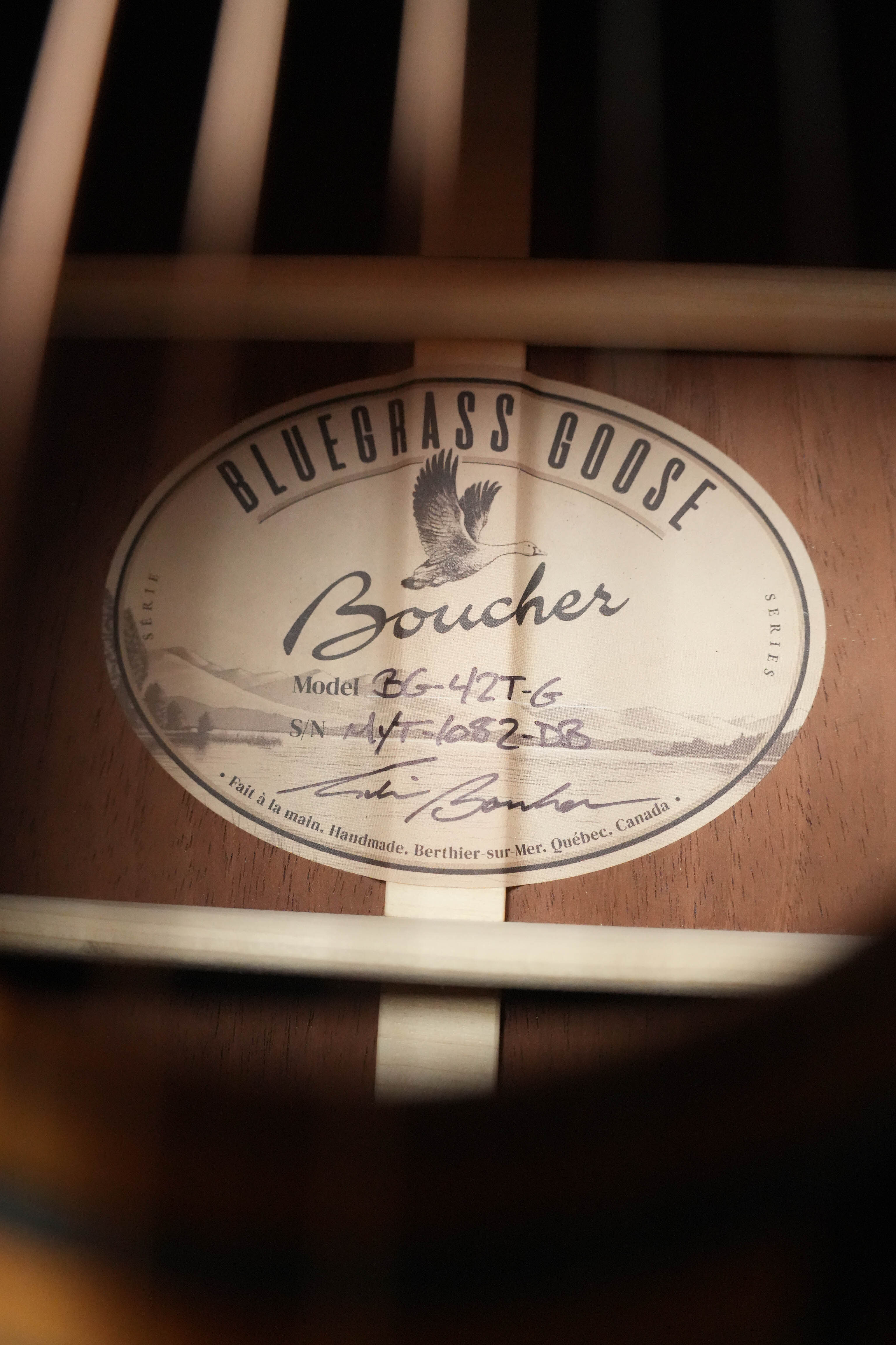 Close-up of a Boucher Guitars BG-42T-G Gold Pack Dreadnought (#1082) label, highlighting its handmade 2026 model with torrefied Adirondack spruce and torrefied mahogany, crafted in Québec, Canada.