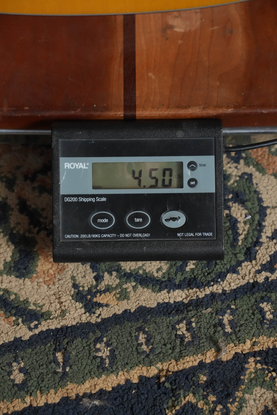 A Royal DG2500 digital shipping scale displays 4.50 lbs on a patterned carpet, with part of a *New 2026 Model* Martin D-10E Retro Road Series Spruce/Sapele Dreadnought Guitar w/Martin Electronics (#9275) by Martin & Co. visible above.