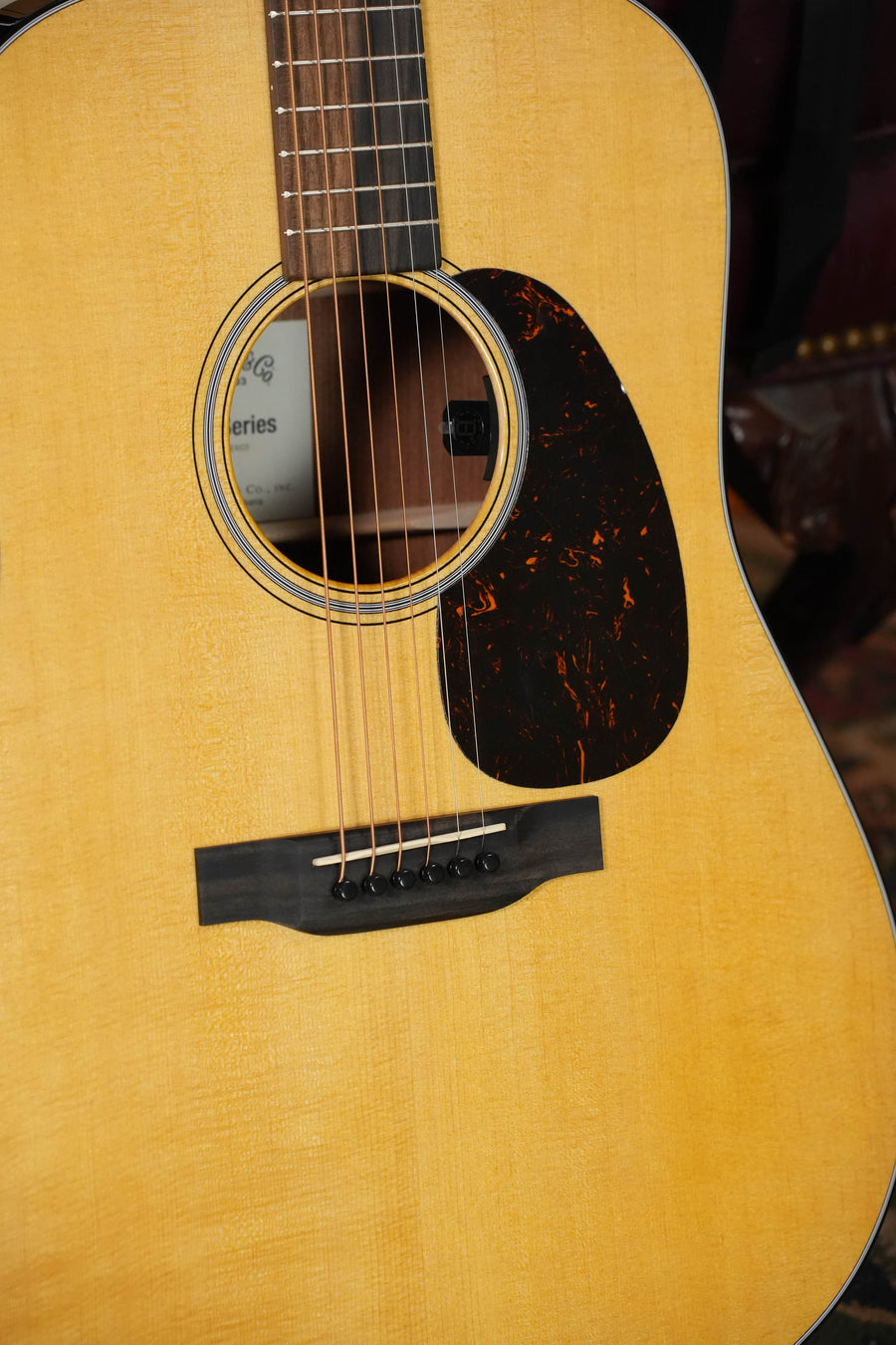 A close-up of the Martin & Co. *New 2026 Model* D-12E Retro Road Series Spruce/Sapele Dreadnought Guitar w/Martin Electronics #3152, highlighting the sound hole, strings, pickguard, and natural finish.