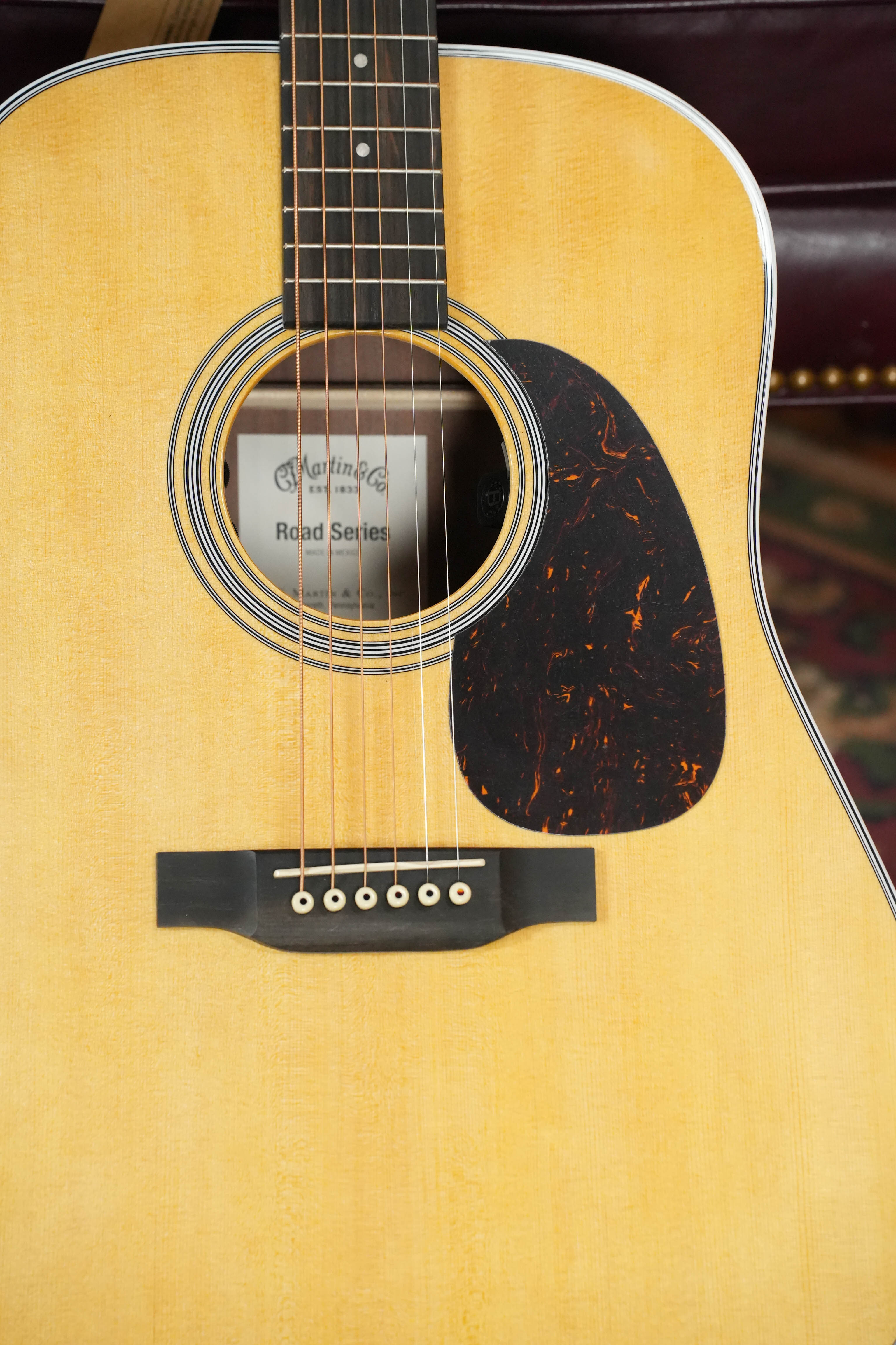 Close-up of the *New 2026 Model* Martin D-13E Retro Road Series Dreadnought by Martin & Co.—showing its solid spruce top, six strings, tortoiseshell pickguard, and the brand label visible inside the sound hole.