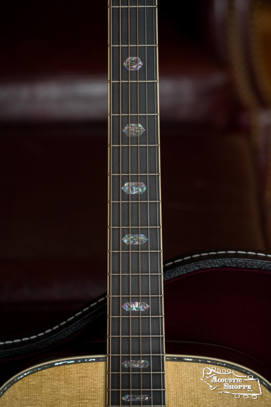 Close-up of the *New 2025 Model* Martin & Co. D-41 Spruce/Indian Rosewood dreadnought acoustic guitar (#1388), highlighting diamond mother-of-pearl inlays on the dark fretboard, with body and maroon background in view.