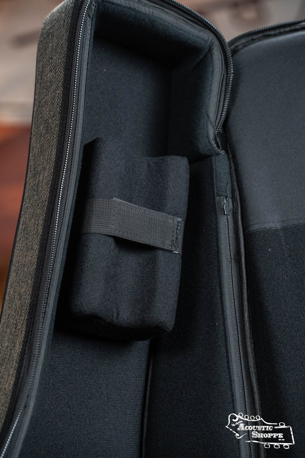 Open Ortega OSOCADN-MO Dreadnought guitar soft case in Mocca with padded interior, small rectangular accessory compartment secured by fabric strap, and Acoustic Shoppe logo in the bottom right corner.