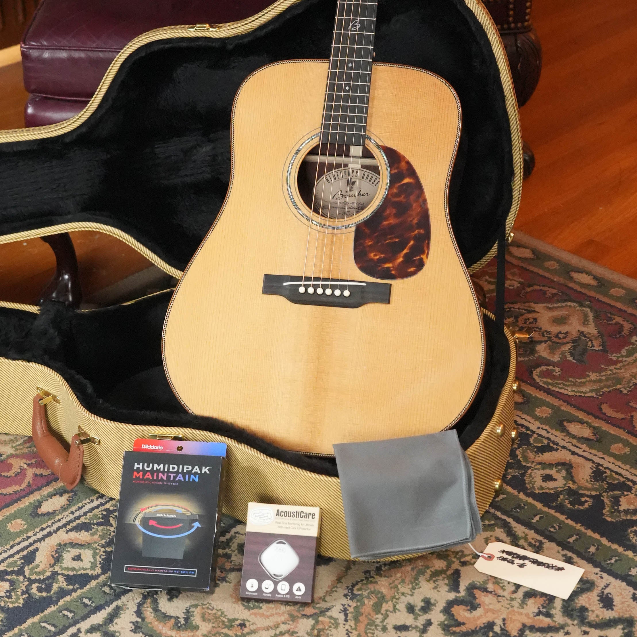 A *Stage Ready* Boucher BG-52-GM Torrefied Adirondack/Rosewood Bluegrass Goose Gold Master Pack Dreadnought Acoustic Guitar (#1415) by Boucher Guitars rests in an open hard case, with cloth, Humidipak Maintain pack, AcousticCare strings, and tag.