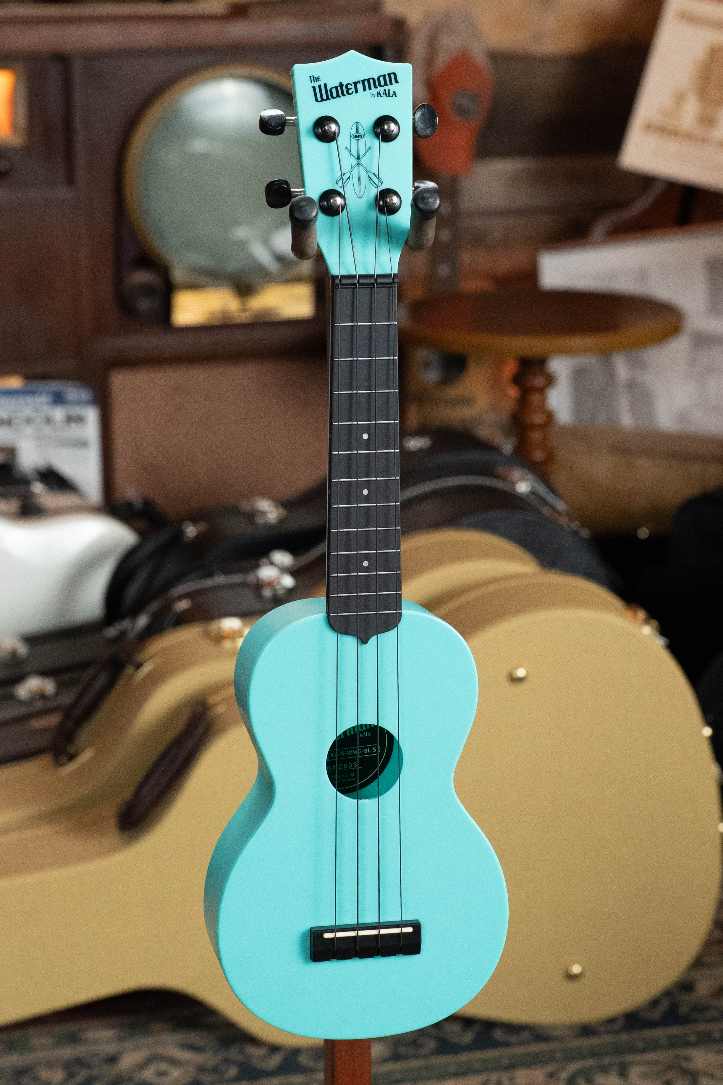 Aqua mist soprano ukulele with black fretboard and Kala logo on headstock, displayed indoors. - The Waterman Aqua Mist Glow-In-The-Dark Soprano Recycled Ukulele - Kala Brand - Default Title