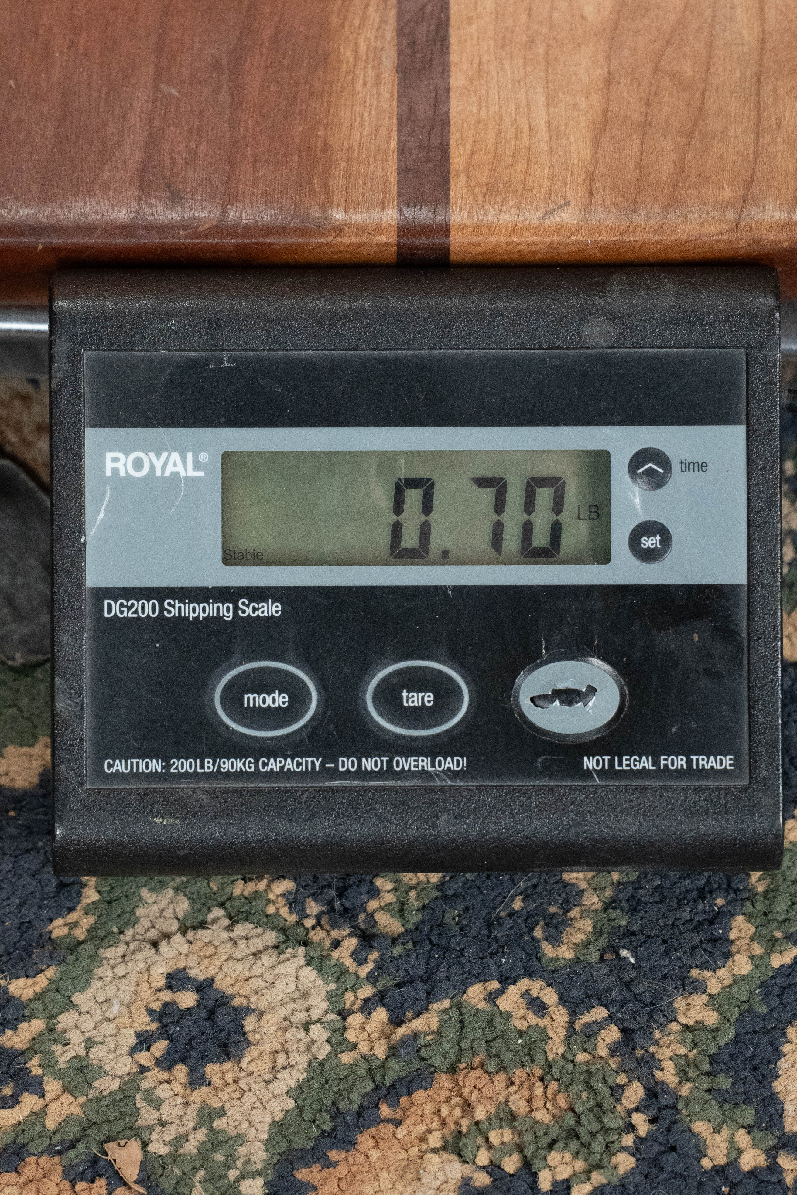 Digital shipping scale displaying 0.70 weight with wood surface background and patterned carpet underneath. - Ukadelic Seascape Soprano Ukulele - Kala Brand - Default Title
