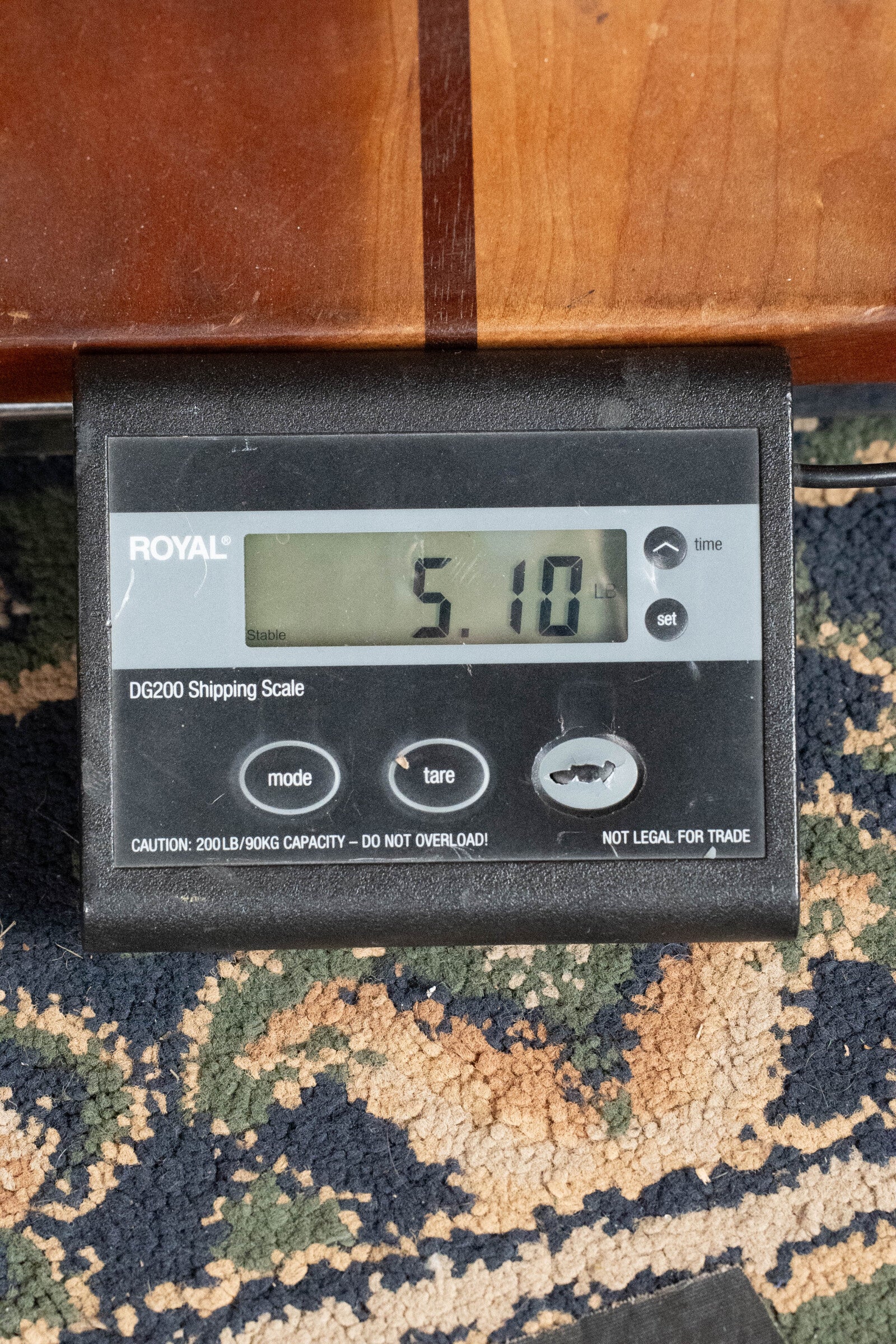 A digital Royal DG200 shipping scale on patterned carpet reads 5.10 lbs—ideal for safely shipping your Taylor Guitars (Used) 2009 614CE Torrefied Sitka/Maple Grand Auditorium Guitar w/Pickup #5110. Model is visible on the display.