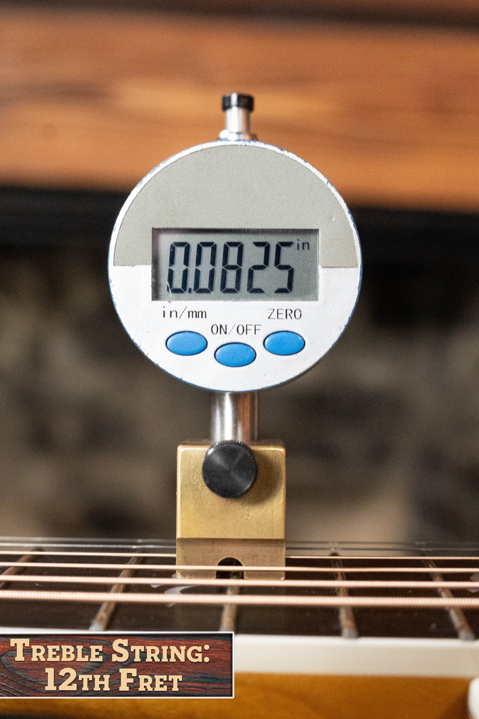 A digital gauge shows 0.0825 as the treble string height at the 12th fret on a (Used) 2009 Taylor Guitars 614CE Torrefied Sitka/Maple Cutaway Grand Auditorium Guitar w/Pickup #5110. A nearby sign reads, Treble String: 12th Fret.