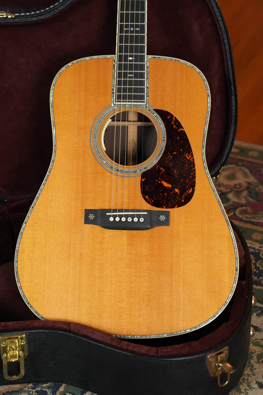 A close-up of a (Used) 2011 Martin & Co. D-42 Sitka/Solid East Indian Rosewood D-14 dreadnought guitar w/LR Baggs Anthem, in an open plush-lined hard case, on a patterned rug.