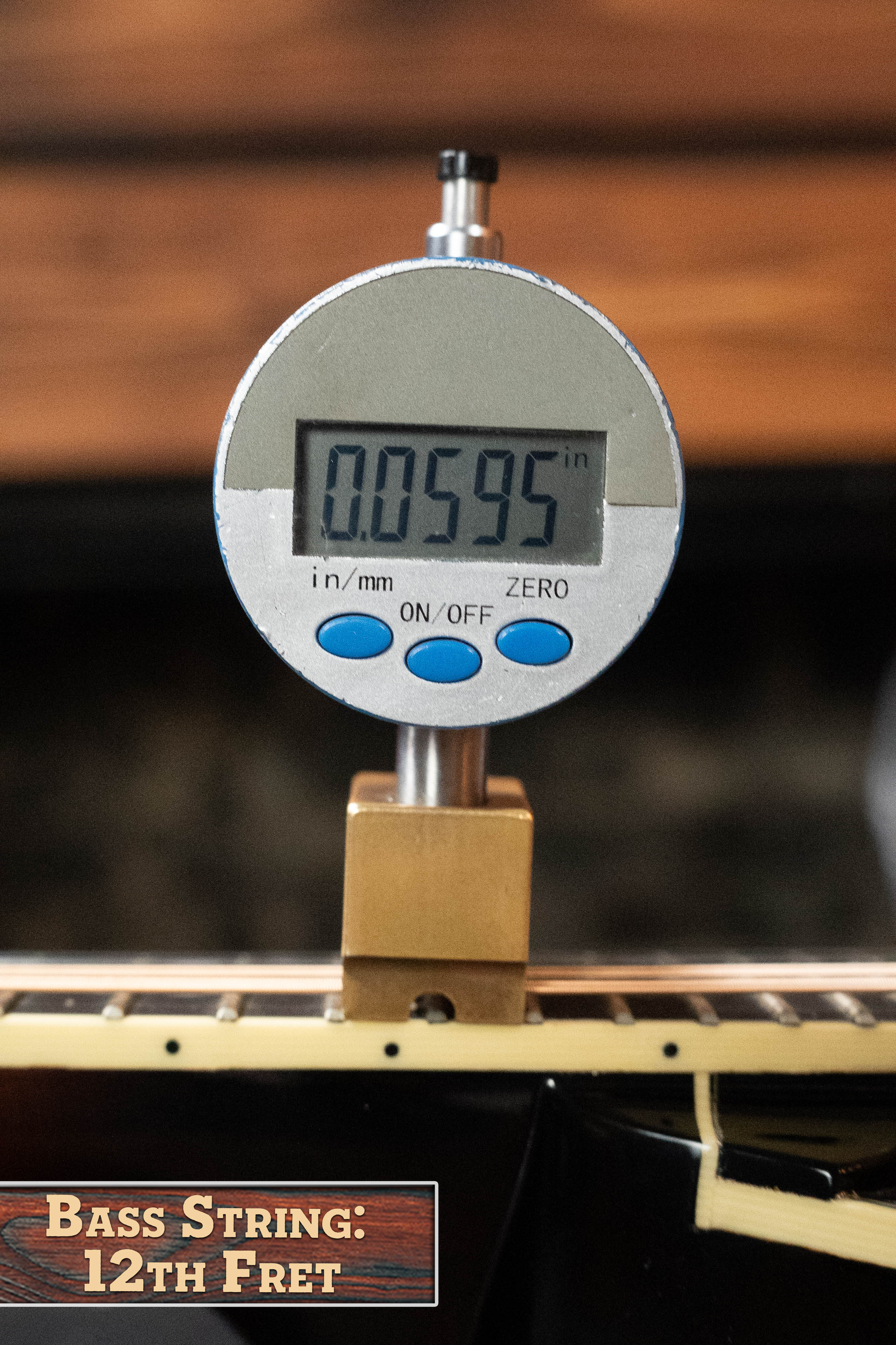 A digital caliper shows 0.0595 inches when measuring string height at the 12th fret. Label reads "Bass String: 12th Fret", similar to checking action on a Weber (Used) 2016 Fern Red Spruce/Flamed Maple A-Style Mandolin #2801.