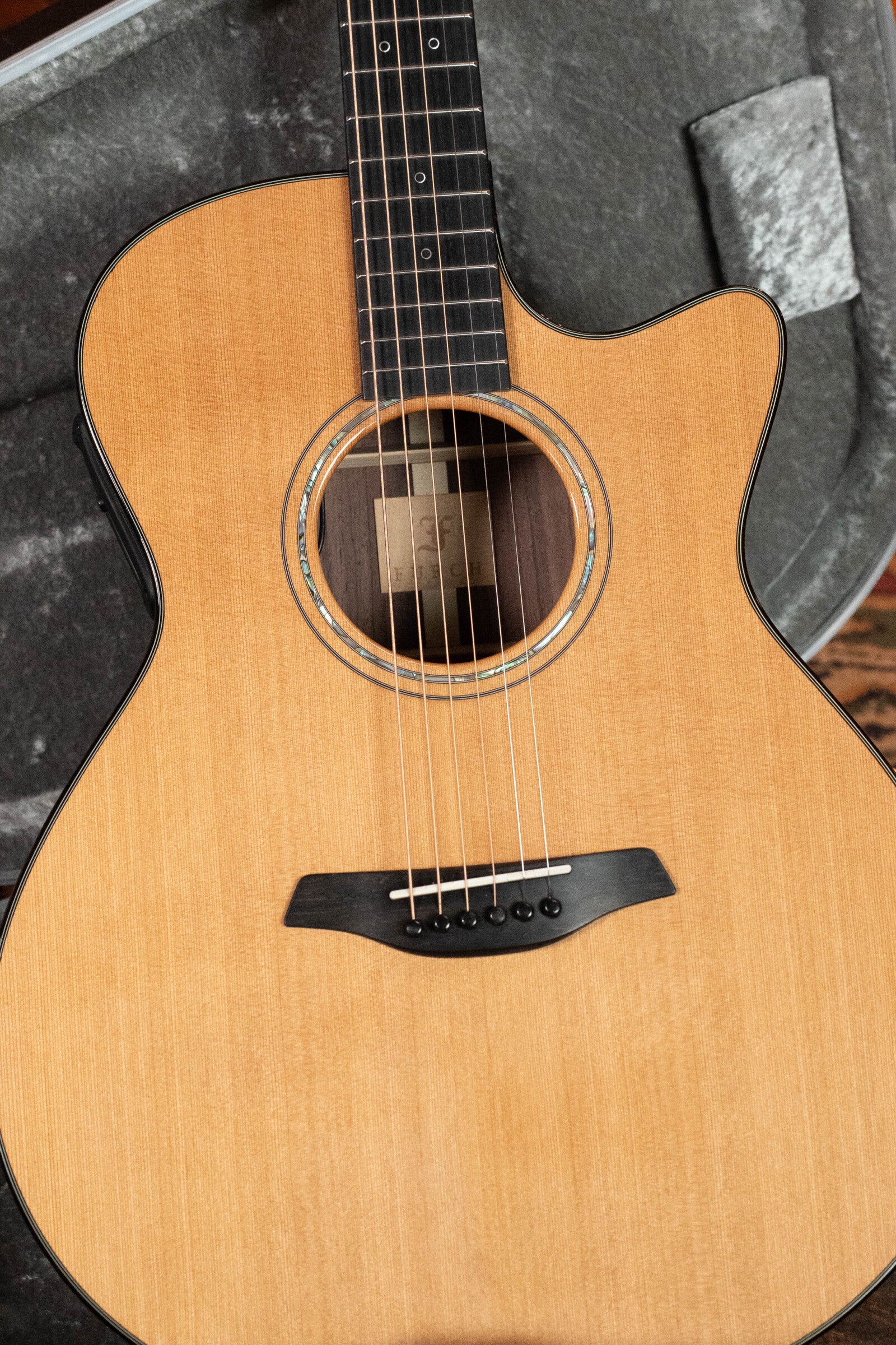 A close-up of a (Used) 2020 Furch Yellow Gc-CR Red Cedar/Rosewood Grand Auditorium Acoustic Guitar (#3716), featuring a light wood finish and six strings, resting in an open gray-lined case.