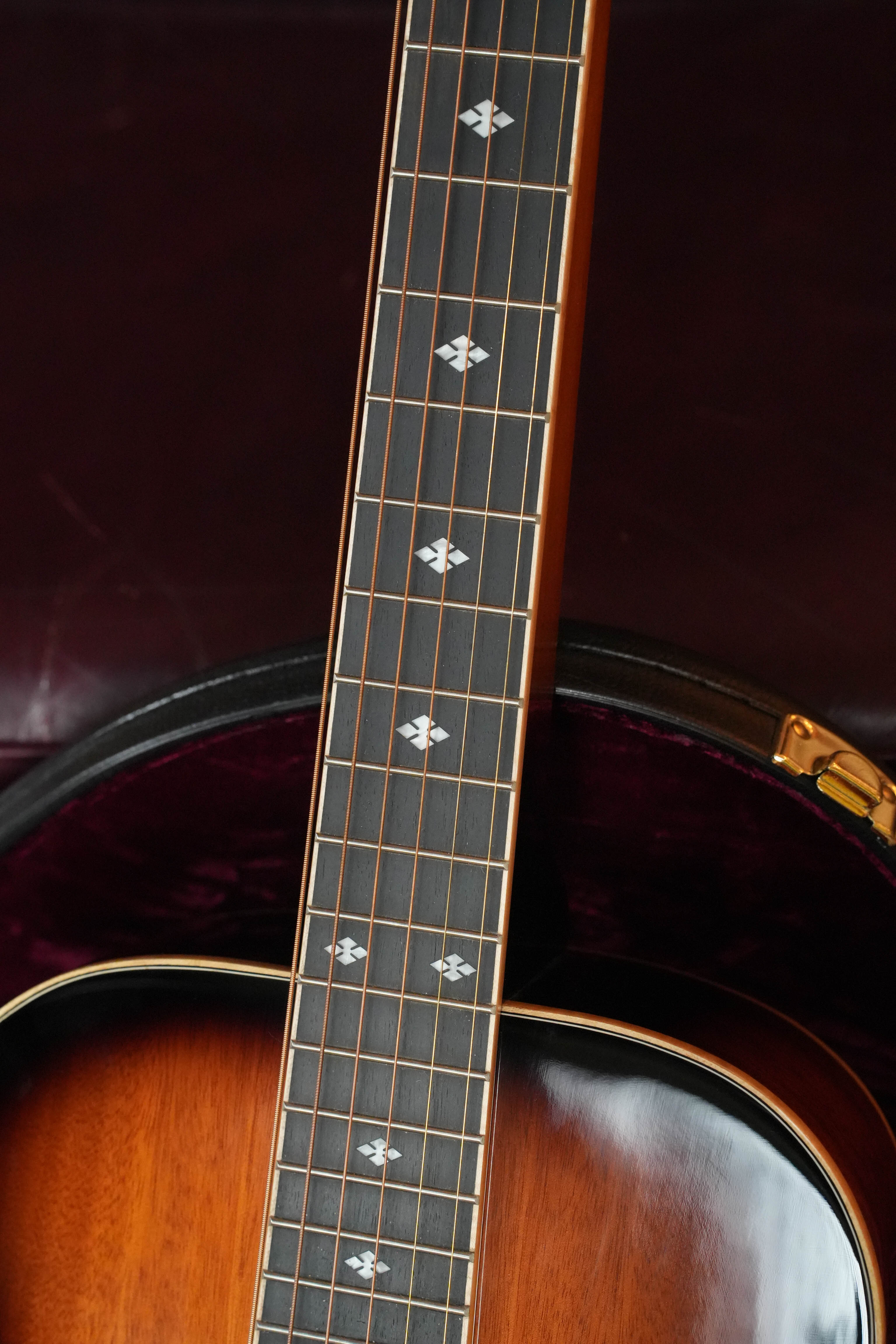 A close-up of a (Used) 2022 Gold Tone PBS-D Paul Beard Deluxe Solid Mahogany Square-Neck Resonator Guitar #8165 shows diamond inlays on the fretboard, with the instrument resting in a dark, plush-lined case.