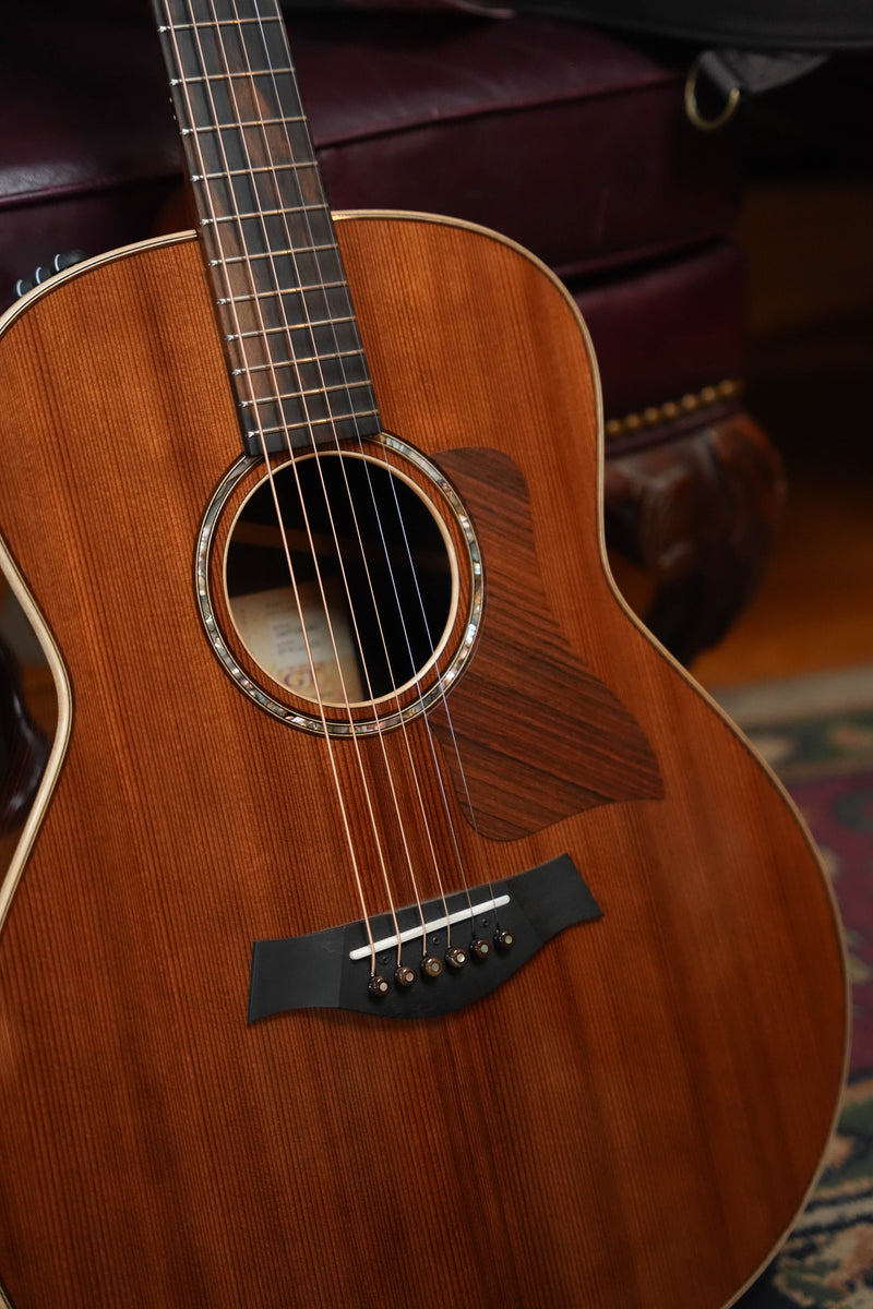 Taylor GT811e LTD Grand Theater, front view with redwood top, dark pickguard, and soundhole.