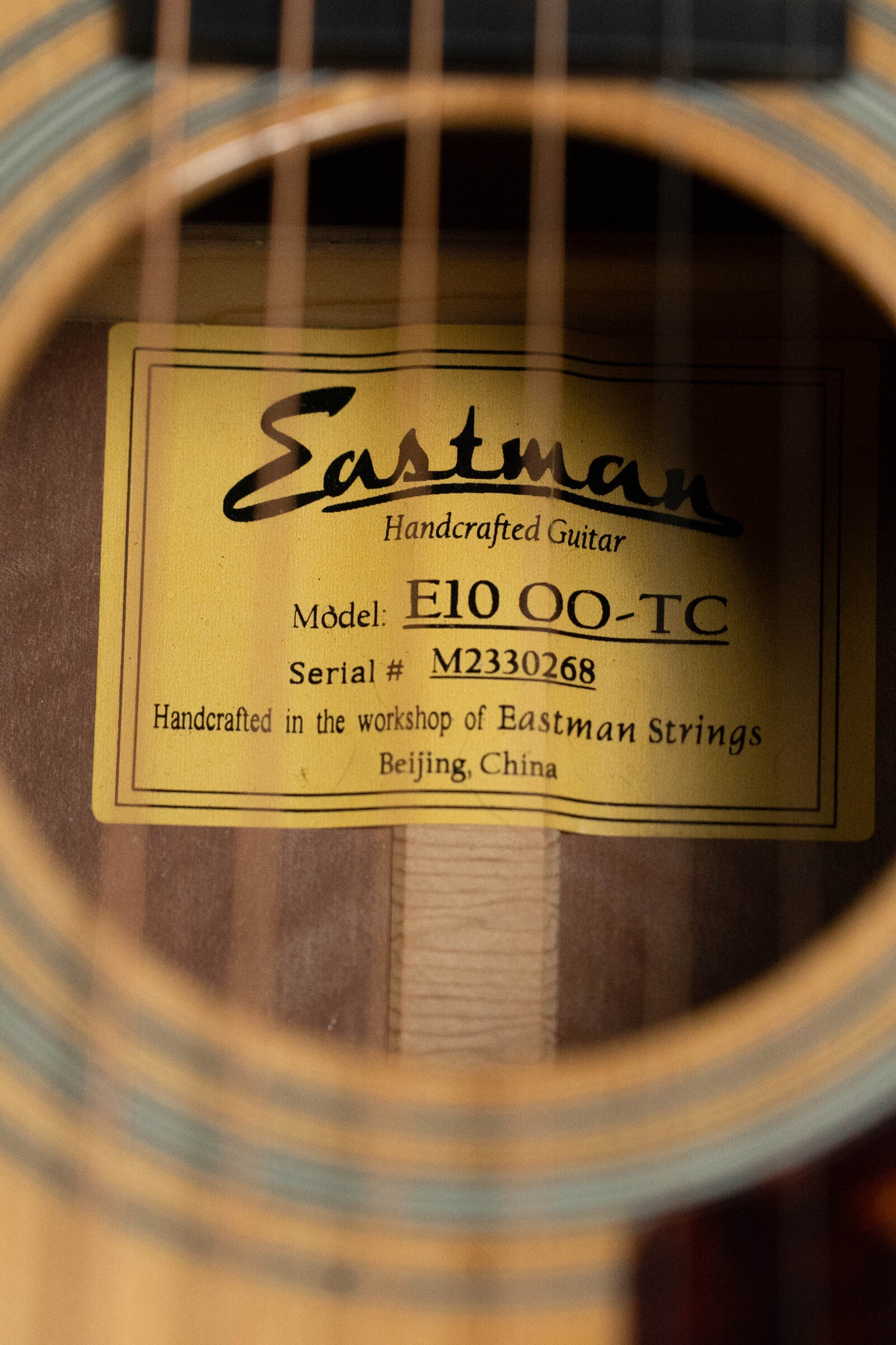 Close-up of the label inside an Eastman Guitars (Used) 2024 E10OO-TC Thermo-Cure Adirondack/Mahogany Acoustic Guitar #0268, handcrafted in Beijing and inspired by Pre-War parlor guitars.