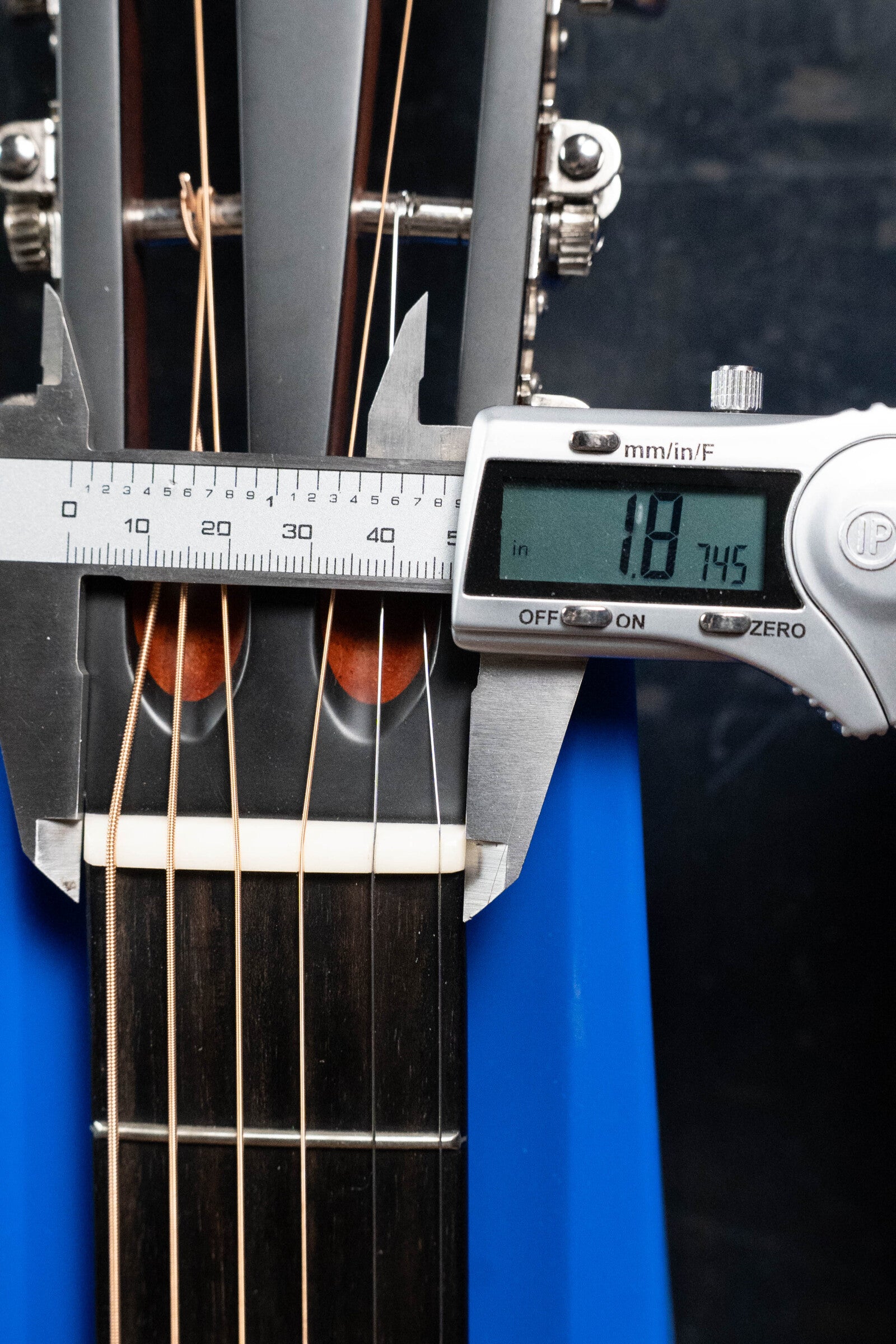 A digital caliper shows the nut width of the (Used) 2024 Eastman E10OO-TC Thermo-Cure Adirondack/Mahogany Acoustic Guitar #0268 at 47.45 mm; it has nylon strings and a dark wood fretboard reminiscent of pre-war parlor styles.