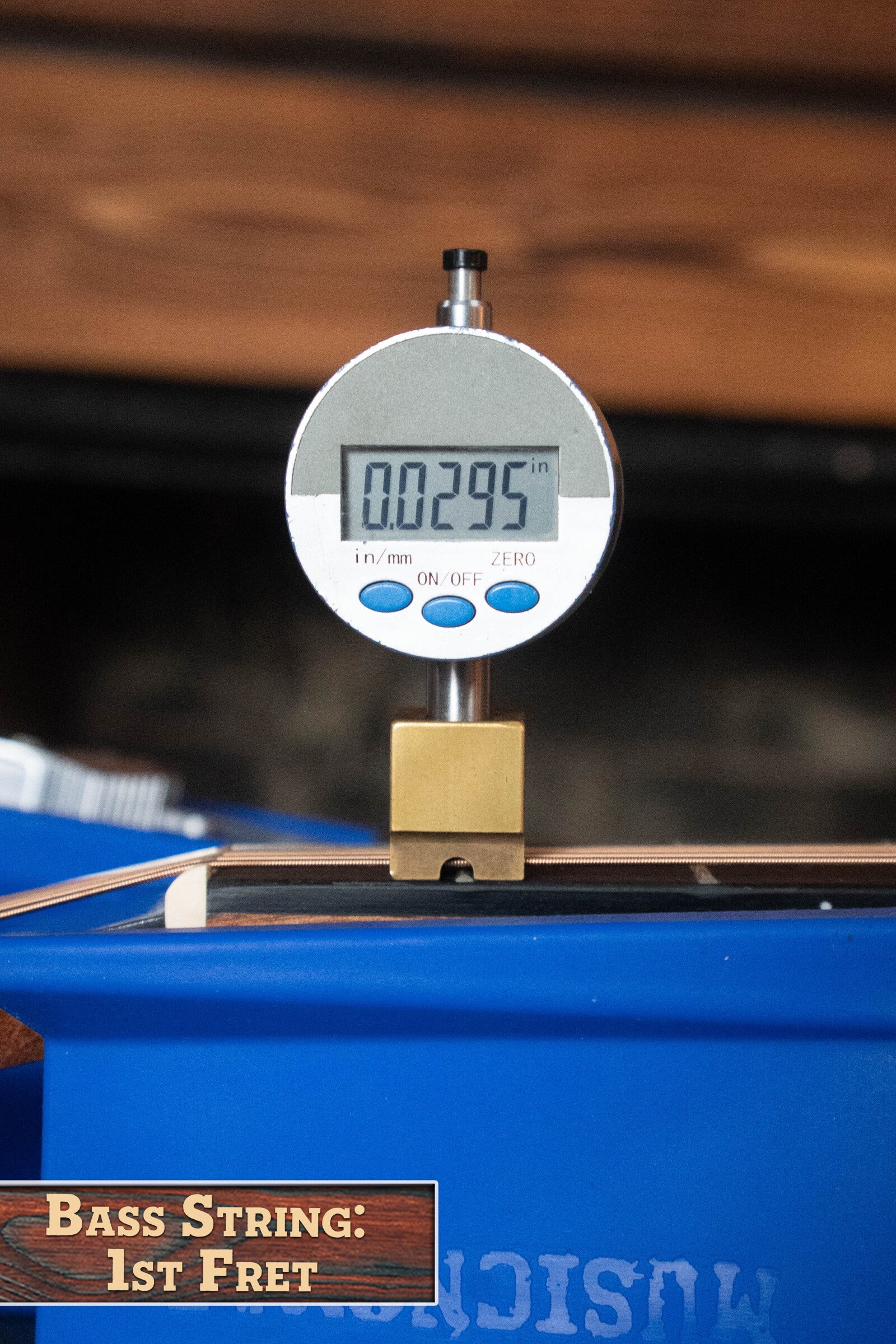 A digital gauge shows 0.0295 when measuring the bass string height at the 1st fret of a (Used) 2025 Alvarez RD-26 Spruce/Mahogany Dreadnought Acoustic Guitar #0161 by Alvarez, on a blue surface labeled Bass String: 1st Fret.