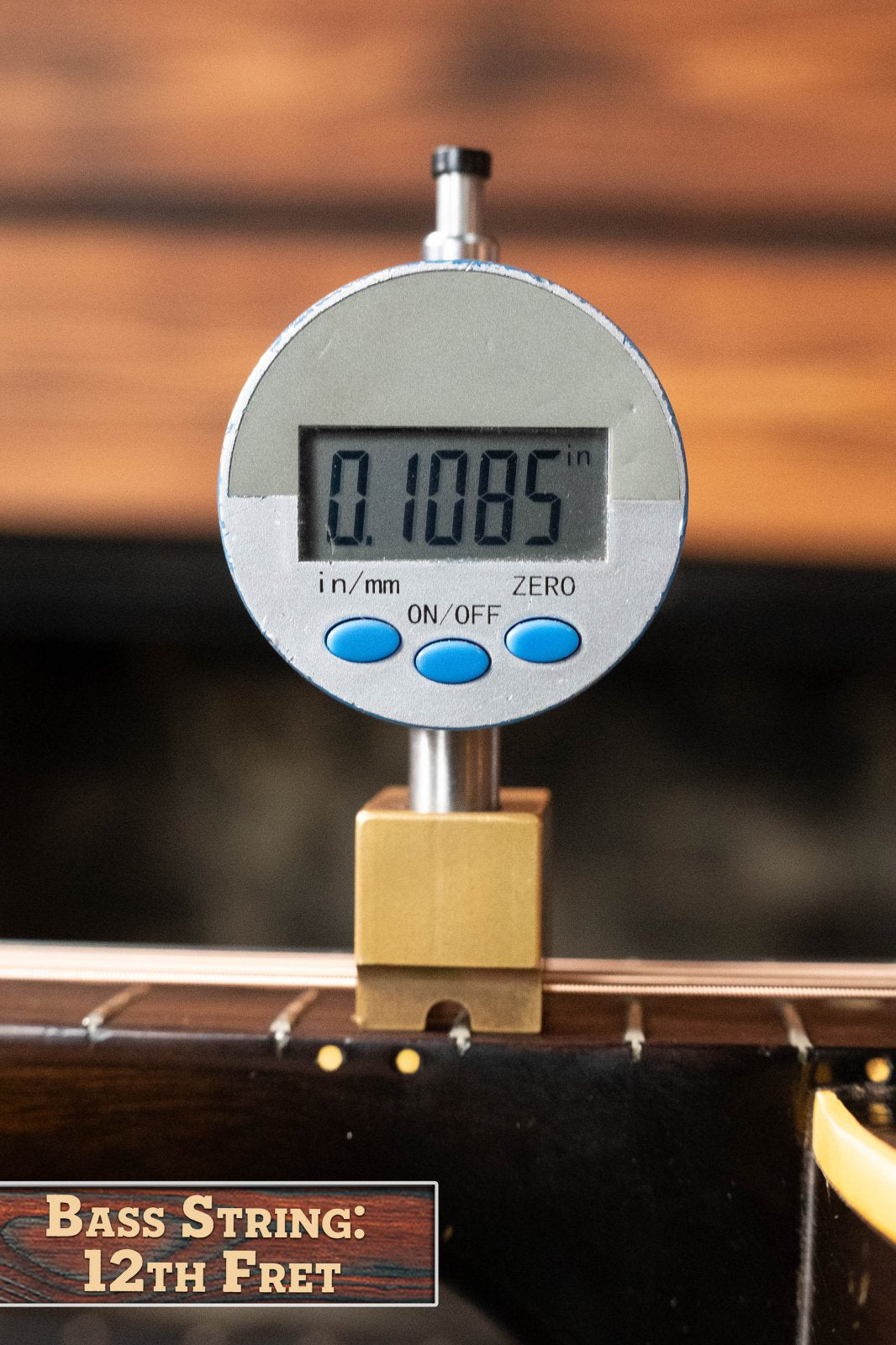 A digital gauge displays 0.1085 inches while checking string height at the 12th fret of a (Used) 1958 Gibson LG-1 Spruce/Mahogany Acoustic Guitar #2758, ideal for authentic vintage Gibson setups.