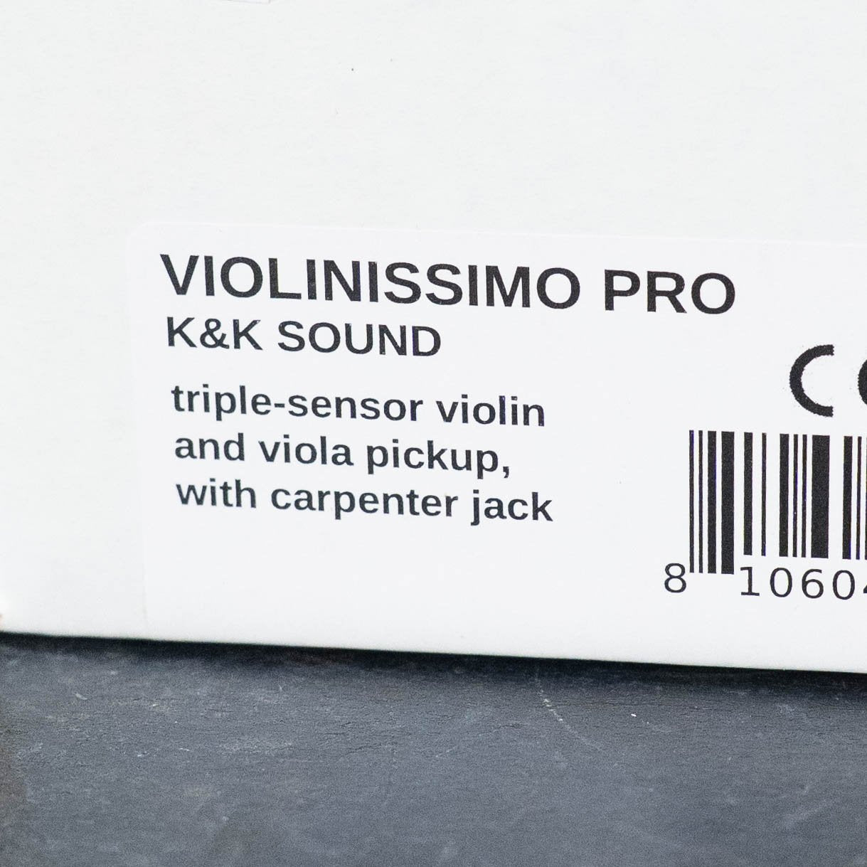 The K&K Sound Violinissimo Pro Carpenter Jack is a triple-sensor pickup for violin or viola, providing balanced sound and featuring a carpenter jack; shown next to a partial barcode on a white background.