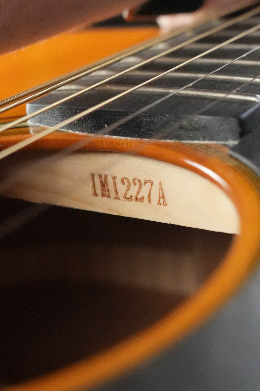 Close-up of a Yamaha FG5 GL NEW Gloss Red Label Dreadnought Acoustic Guitar #227A soundhole and strings, showcasing the solid Sitka spruce top and an internal wooden support stamped #227A.