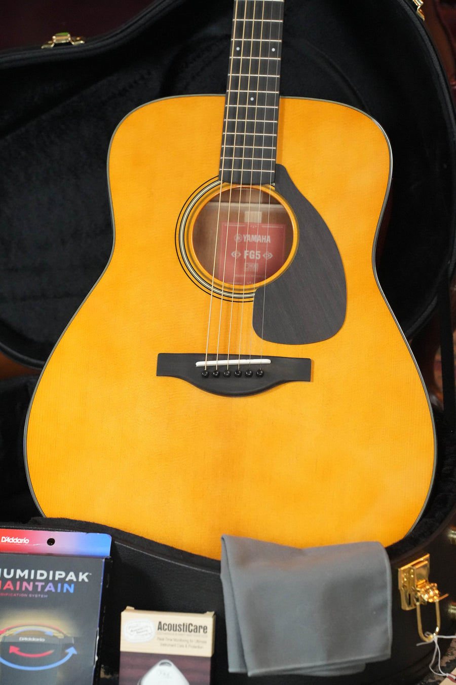 The Yamaha FG5 GL NEW Gloss Red Label Dreadnought Acoustic Guitar #732A by Yamaha features a solid Sitka spruce top, natural finish, black pickguard, and comes in a hard case with cleaning cloth, humidipak, and AcousticCare items.