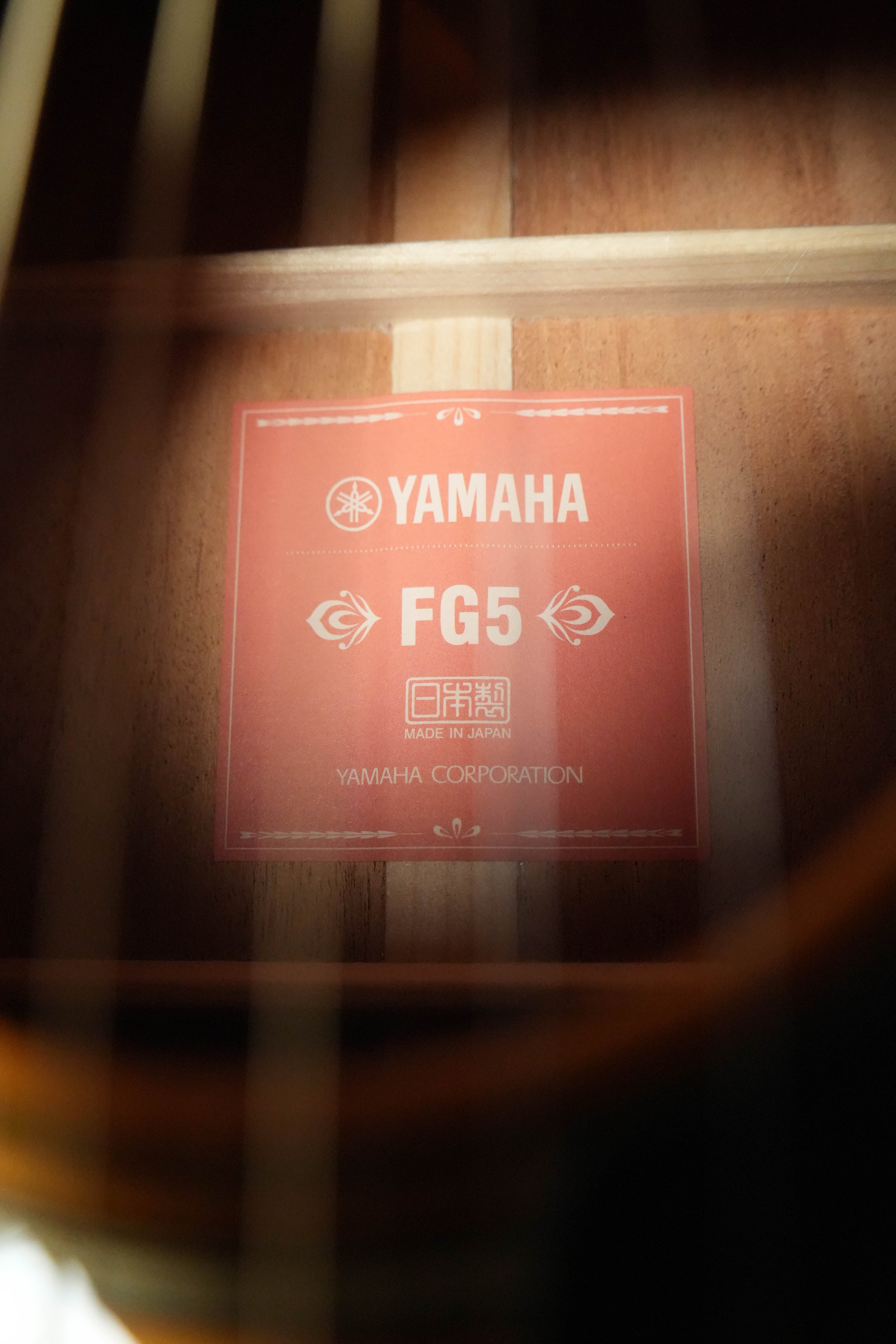 Close-up of a Yamaha FG5 GL NEW Gloss Red Label Dreadnought Acoustic Guitar (#732A), showing the inner label with "Made in Japan" and the solid spruce top, guitar strings, and wood detail visible. Brand: Yamaha.