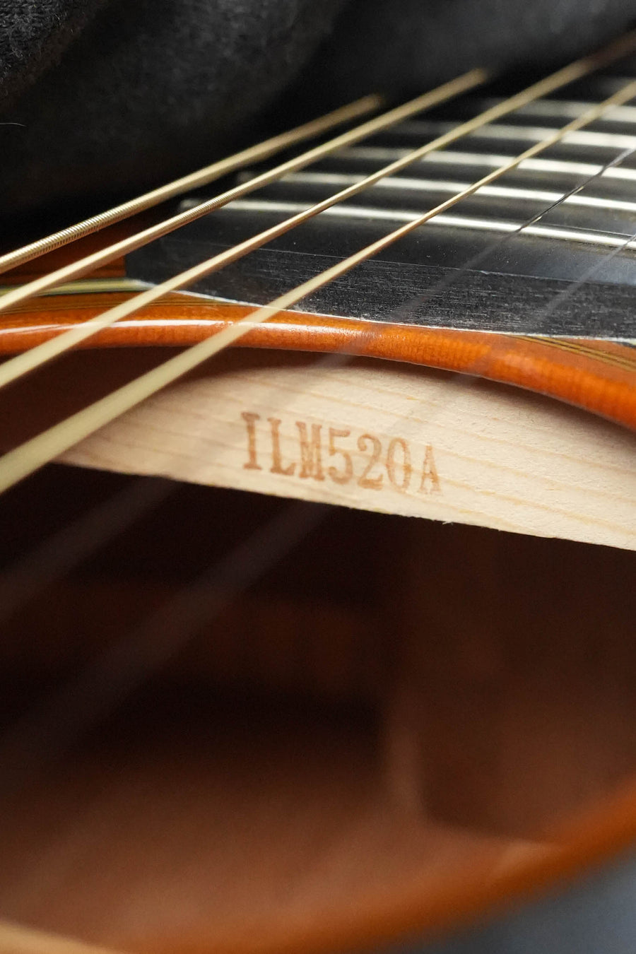 Close-up of the Yamaha FG5 GL NEW Gloss Spruce/Mahogany Red Label Dreadnought Acoustic Guitar #520A sound hole, showing strings and an interior wooden brace; highlights its solid Sitka spruce top.