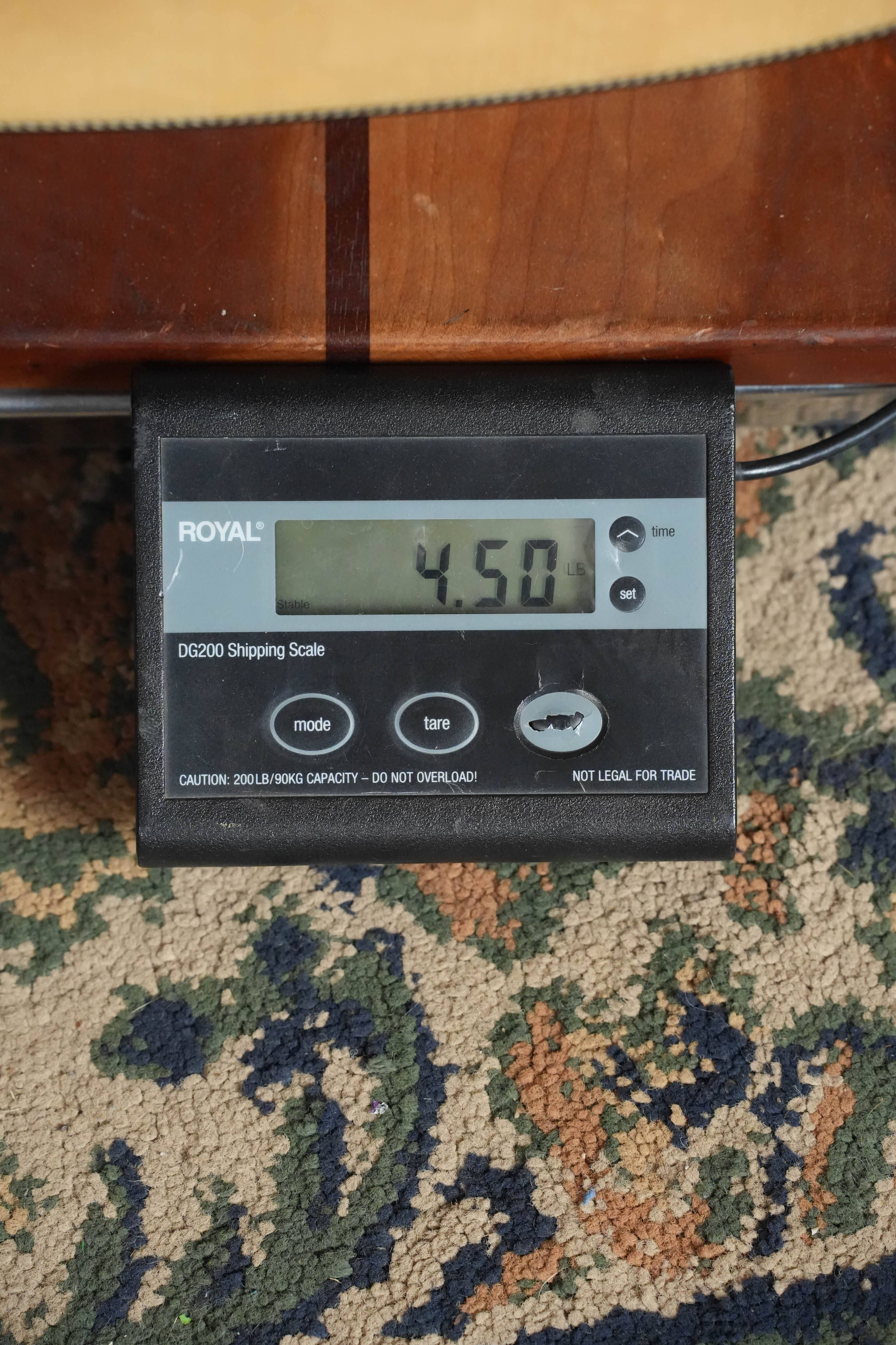 A digital shipping scale reads 4.50 lbs as it measures the Yamaha FG9 M Adirondack/Mahogany Dreadnought Acoustic Guitar #112A, reflecting Yamaha’s signature craftsmanship and attention to detail.
