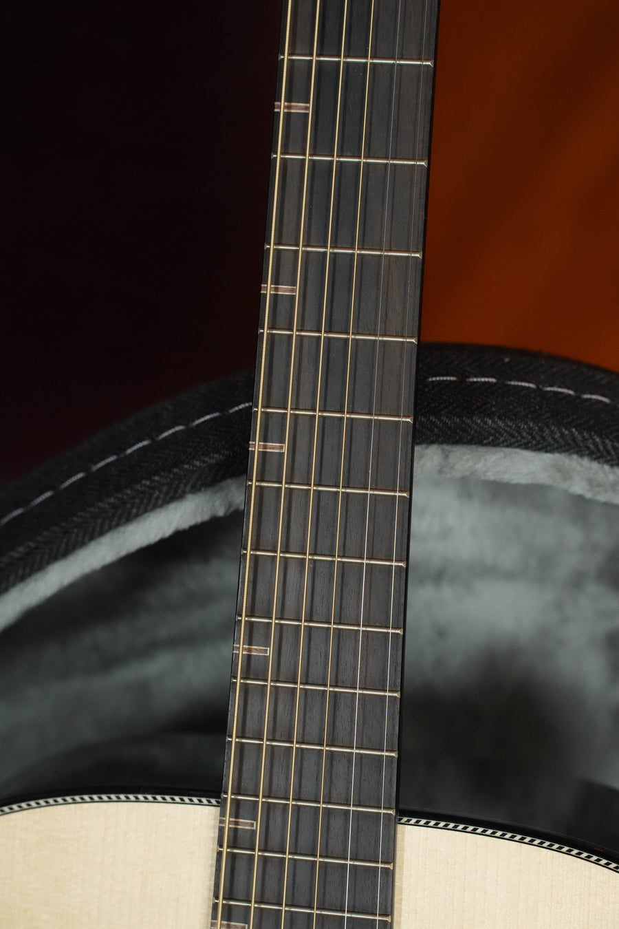 Close-up of an acoustic guitar’s neck and strings, with part of the body and a soft-lined open black case in the background—possibly a Yamaha FG9 R NT Adirondack/Indian Rosewood Dreadnought Acoustic Guitar #113A.