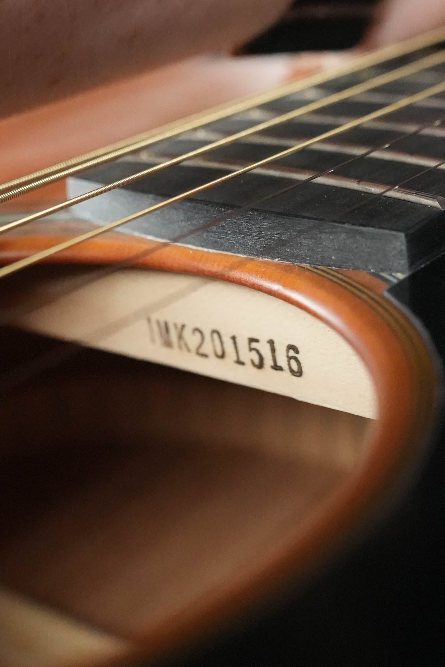 Close-up of the Yamaha FS3 Red Label Concert Acoustic Guitar #1516 by Yamaha, showing its solid Sitka spruce top, metal strings, the wooden interior, and serial number 1516 stamped inside.