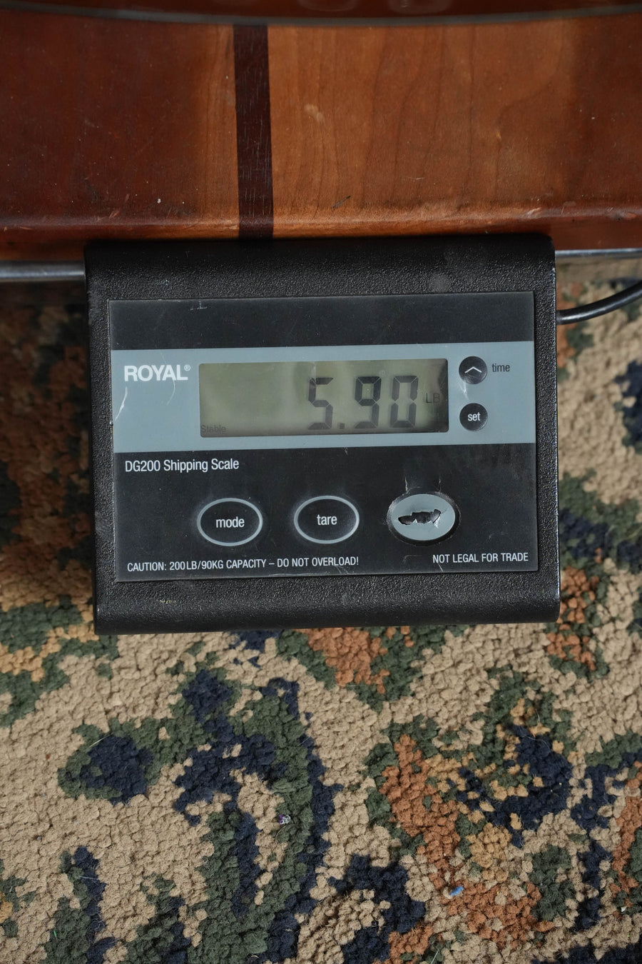 A black ROYAL DG200 Shipping Scale on patterned carpet shows 5.90 lbs while weighing a Yamaha TAG1 C Sitka/Mahogany Sandburst Dreadnought TransAcoustic Guitar w/Cutaway #0610.