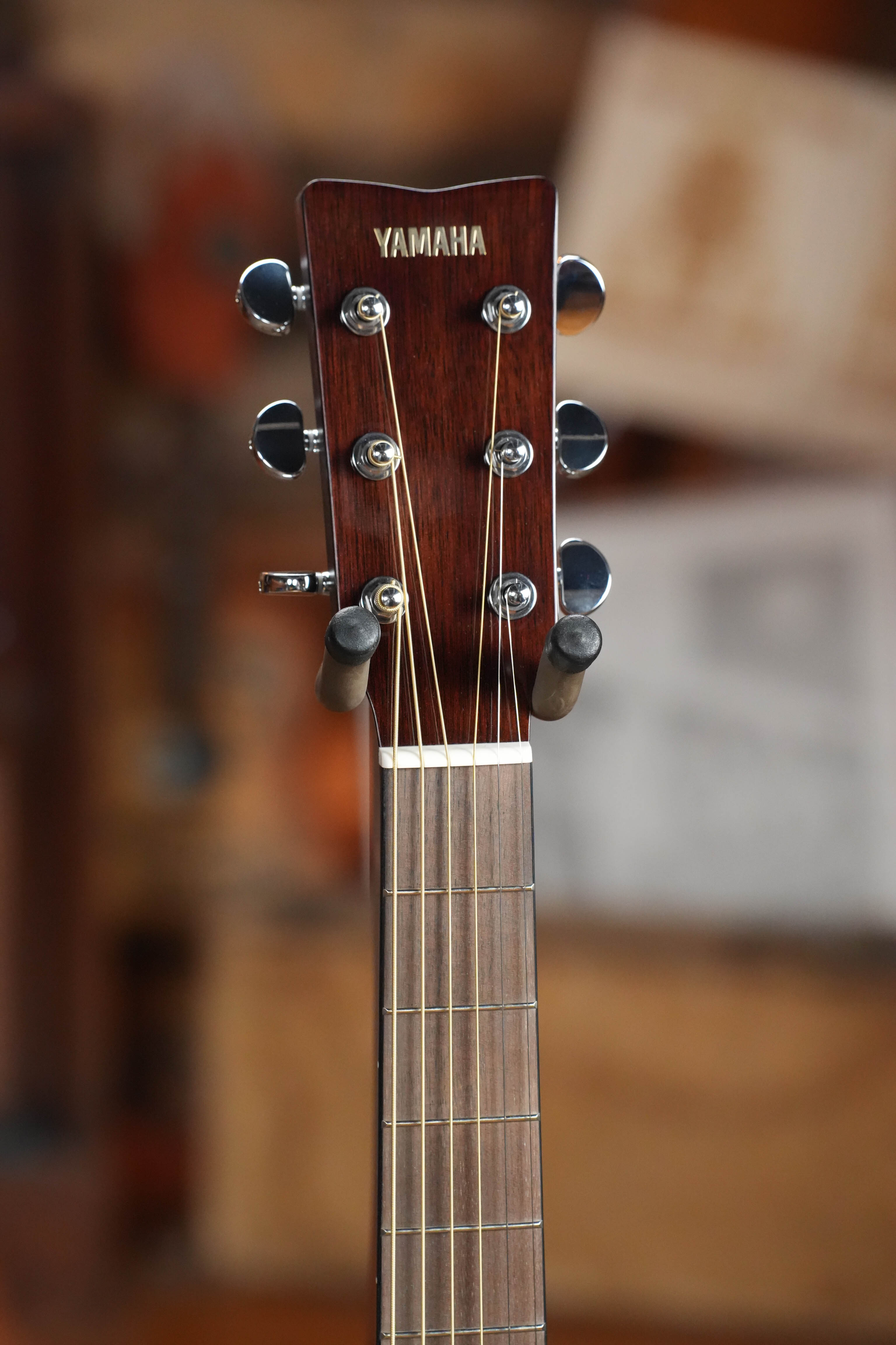 Close-up of the headstock on a Yamaha TAG1E TBL Spruce/Mahogany Transacoustic Dreadnought Guitar #1280, showing its tuning pegs and strings. This Yamaha model features built-in reverb and chorus for enhanced sound.