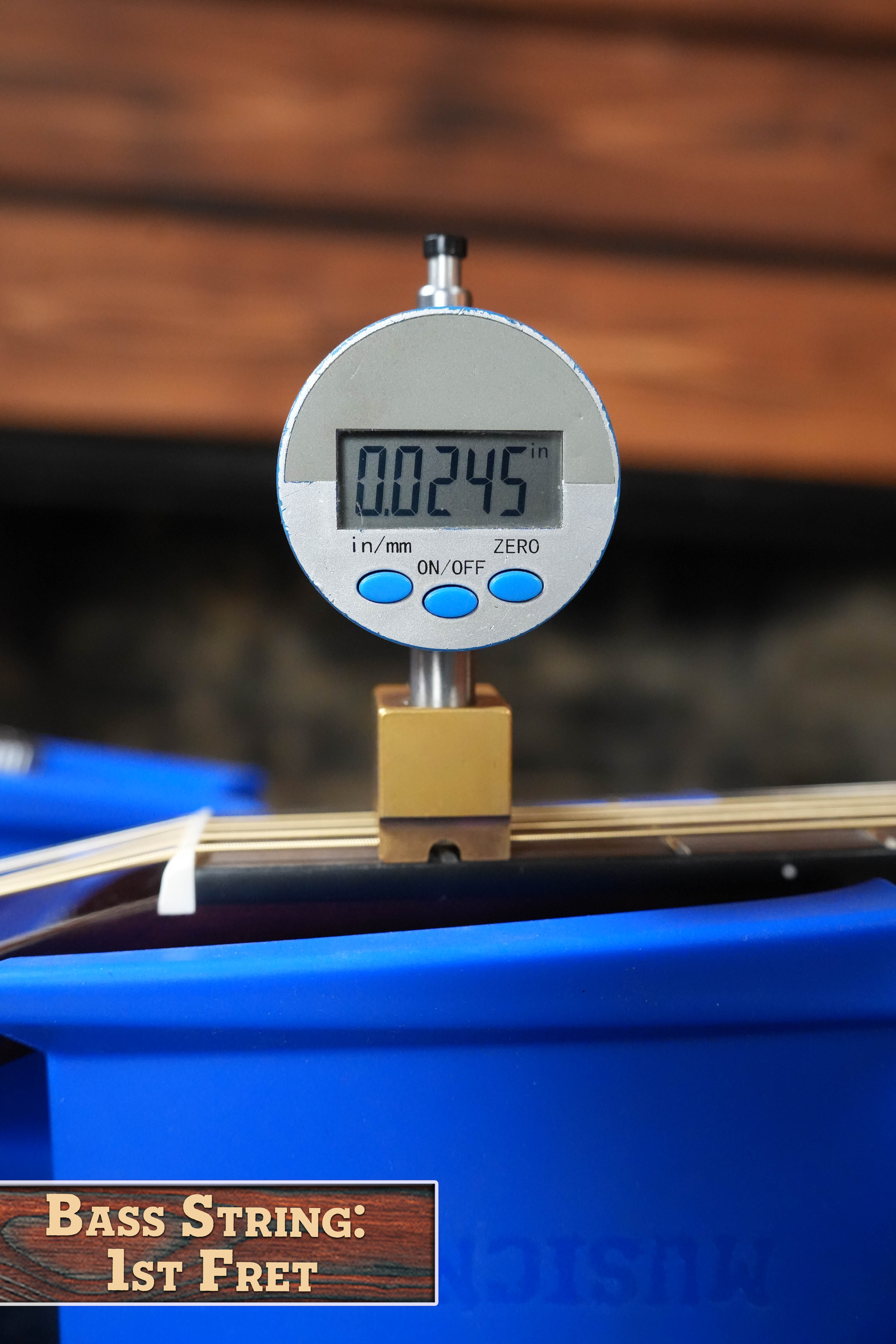 A digital caliper measures the bass string height at the first fret of a Yamaha TAG1E TBL Spruce/Mahogany Transacoustic Dreadnought Guitar #1280 at 0.0245 inches.