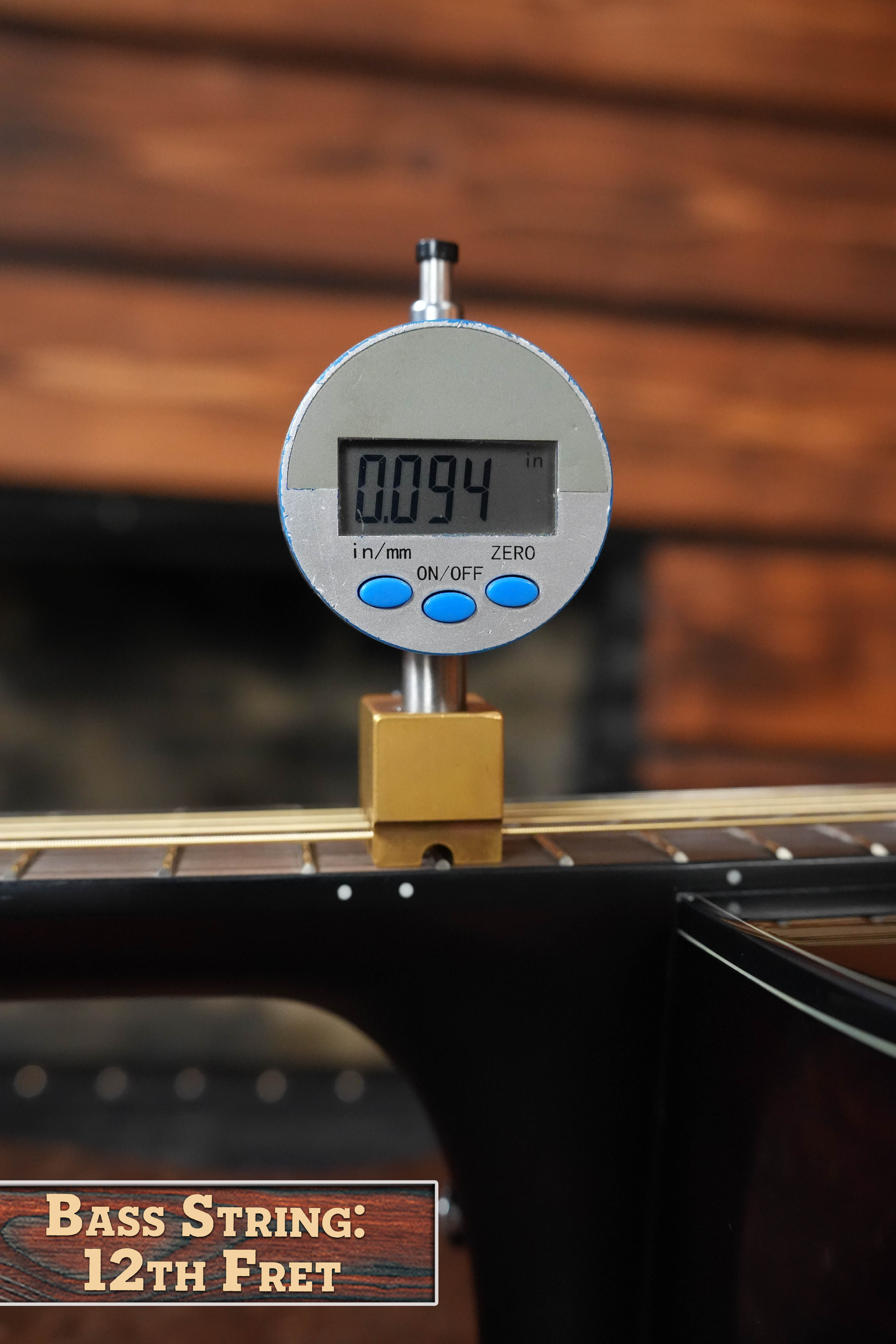 A digital gauge shows the bass string height above the 12th fret on a Yamaha TAG1E TBL Spruce/Mahogany Transacoustic Dreadnought Guitar #1280 at 0.094 inches, with “Bass String: 12th Fret” labeled and spruce/mahogany wood visible.
