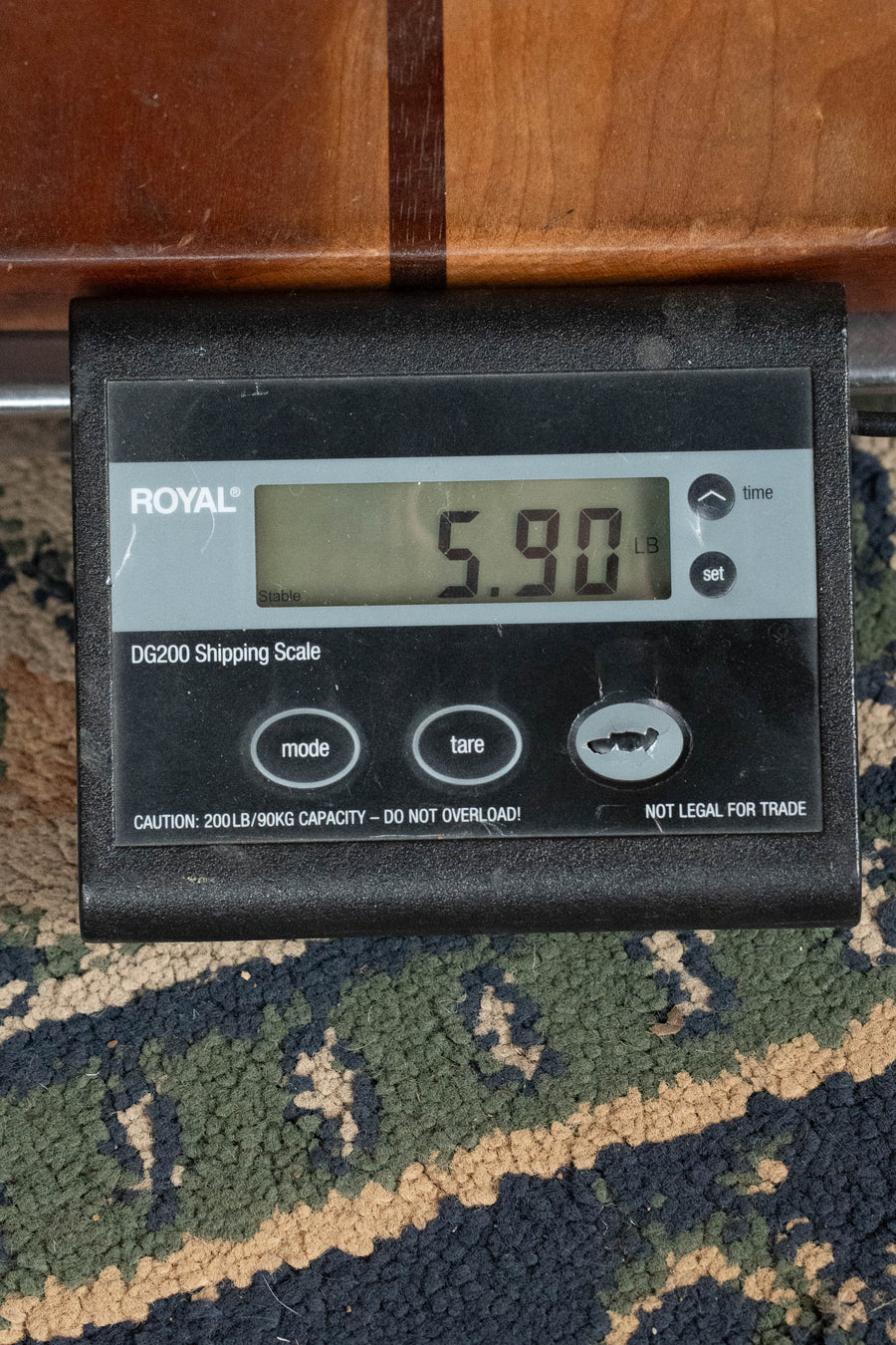 A digital shipping scale shows 5.90 lbs with the Yamaha TAG3C-SDB Sitka/Mahogany Sandburst Dreadnought Guitar (TransAcoustic System #0760) partly visible on a patterned rug above the Royal DG200 Shipping Scale.