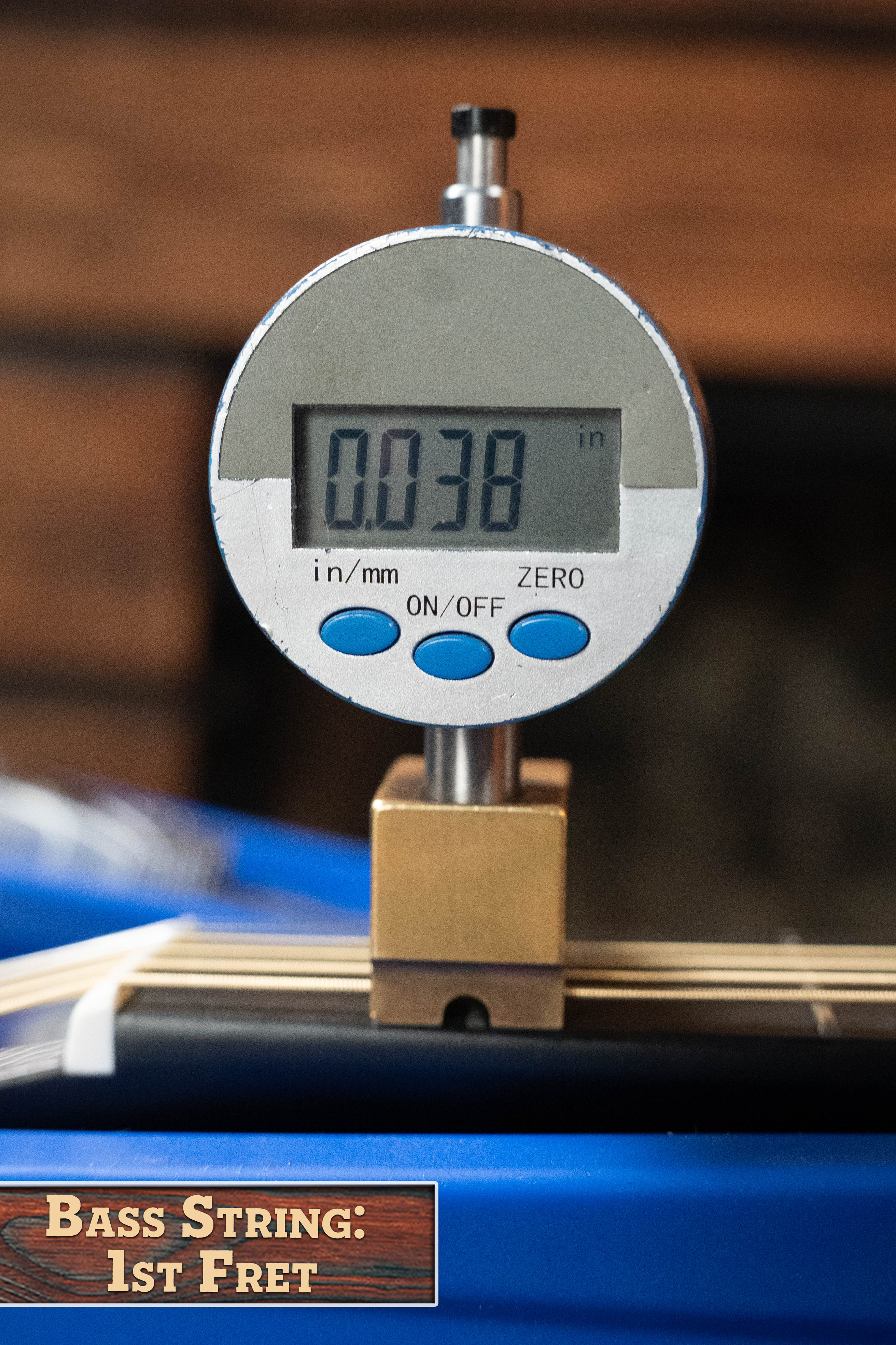 A digital gauge displays 0.038 inches, measuring the bass string height at the 1st fret of a Yamaha TAG3C-SDB Sitka/Mahogany Sandburst Dreadnought Guitar with the NEWEST TransAcoustic System #0688. Label: Bass String: 1st Fret.