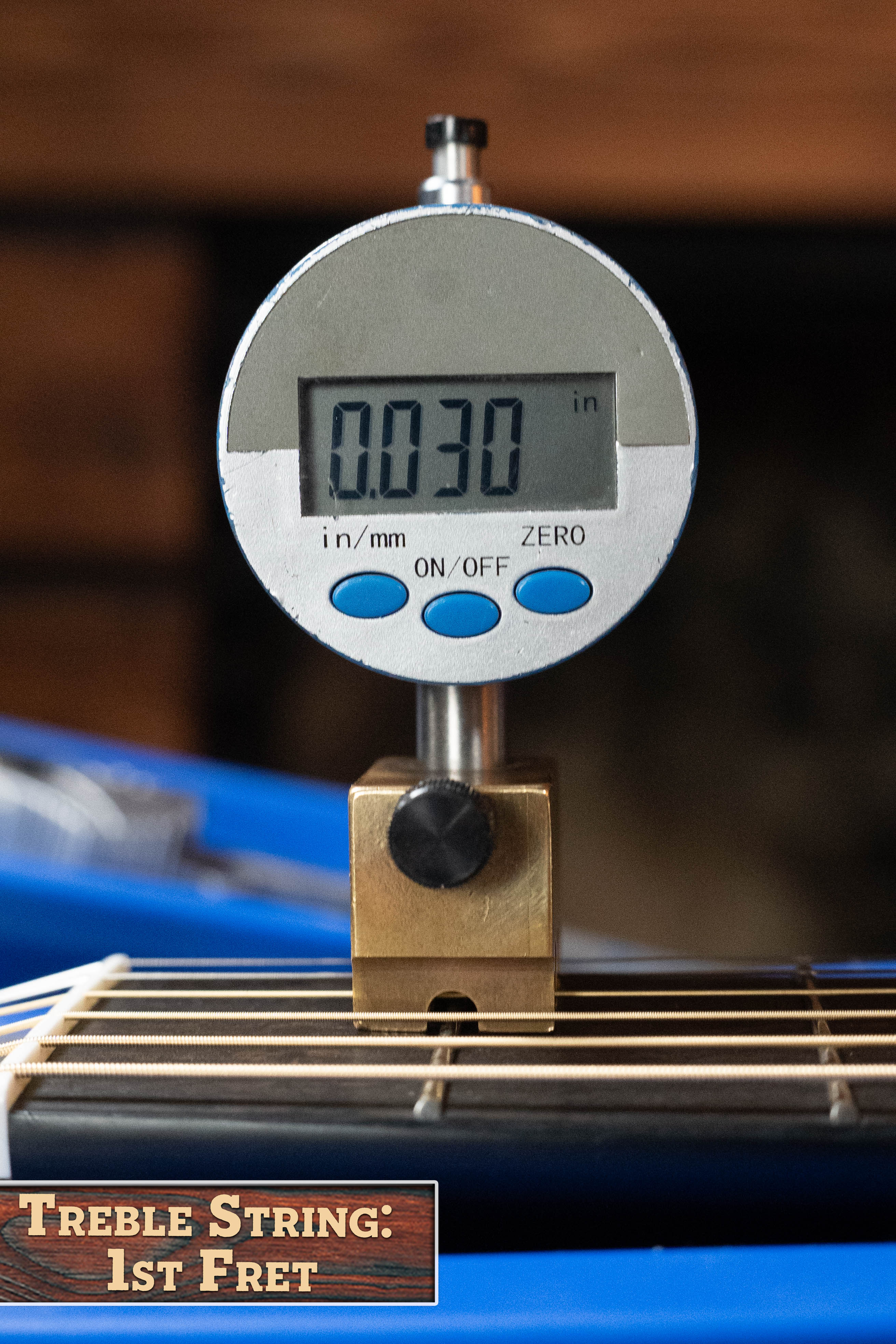 A digital gauge reads 0.030 inches when measuring the treble string at the 1st fret of a Yamaha TAG3C-SDB Sitka/Mahogany Sandburst Dreadnought Guitar with the NEWEST TransAcoustic System #0688; label: Treble String: 1st Fret.
