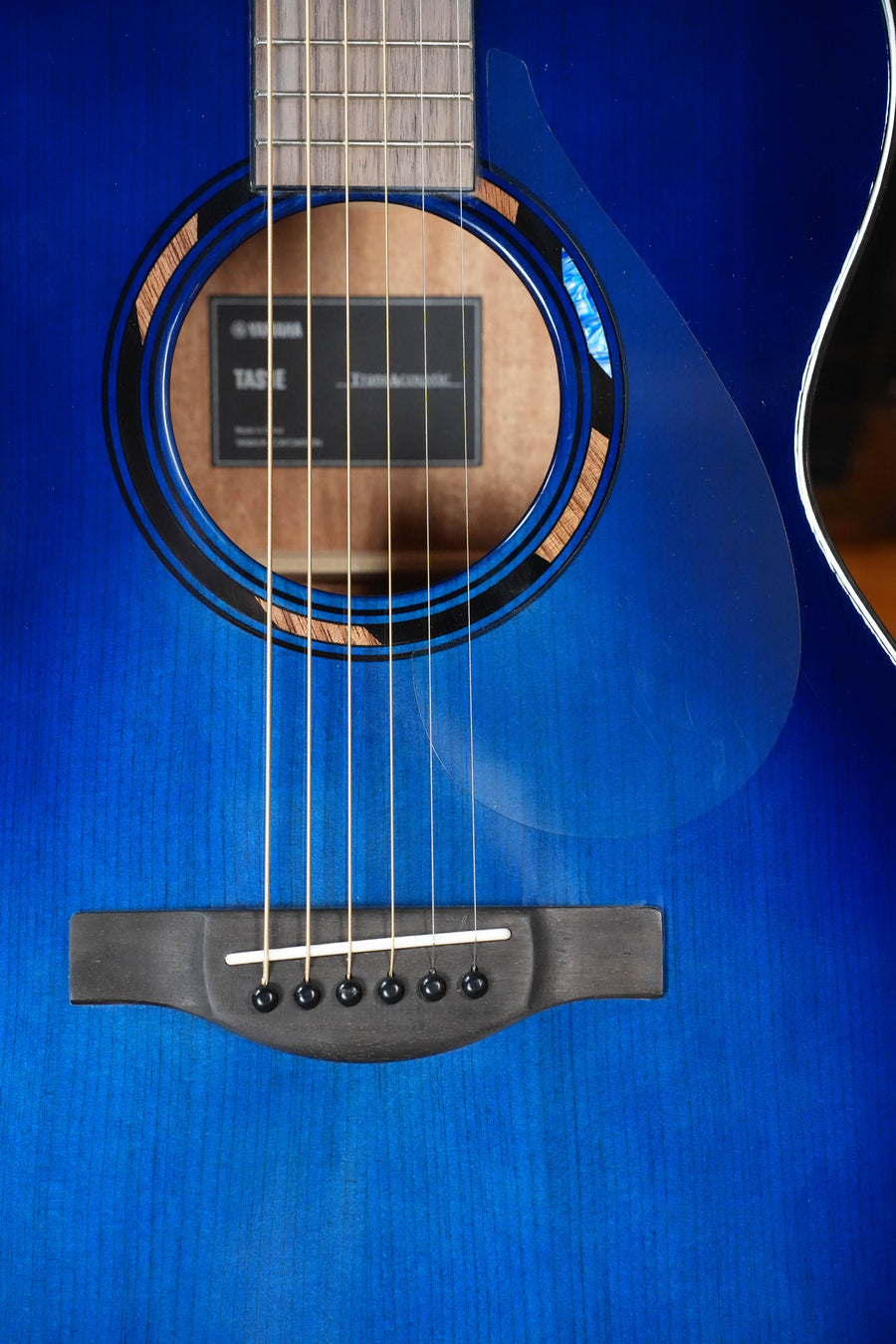 Close-up of the Yamaha TAS1E Ultra Marine Spruce/Mahogany Transacoustic Concert Guitar #1161, highlighting strings, sound hole with label, and bridge—showcasing Yamaha’s innovative TransAcoustic system.